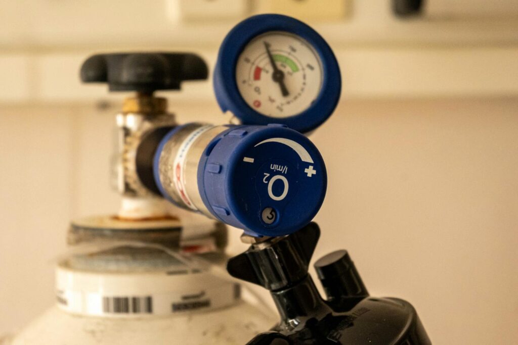 Photo by Vladimir Srajber Detailed view of an oxygen tank with a pressure gauge, showcasing medical equipment usage.